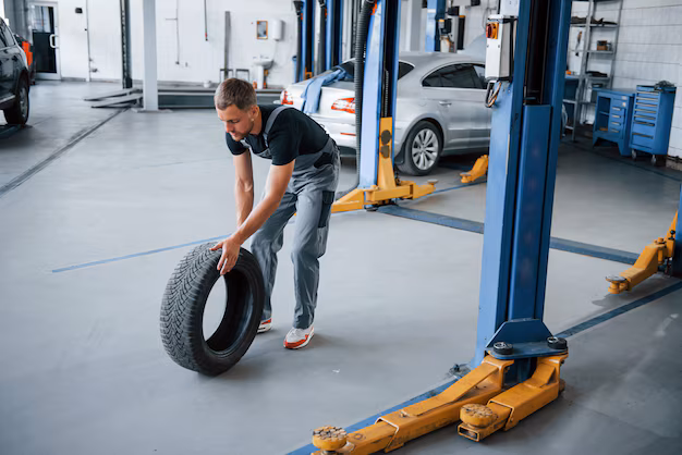 mechanic rolling a tire